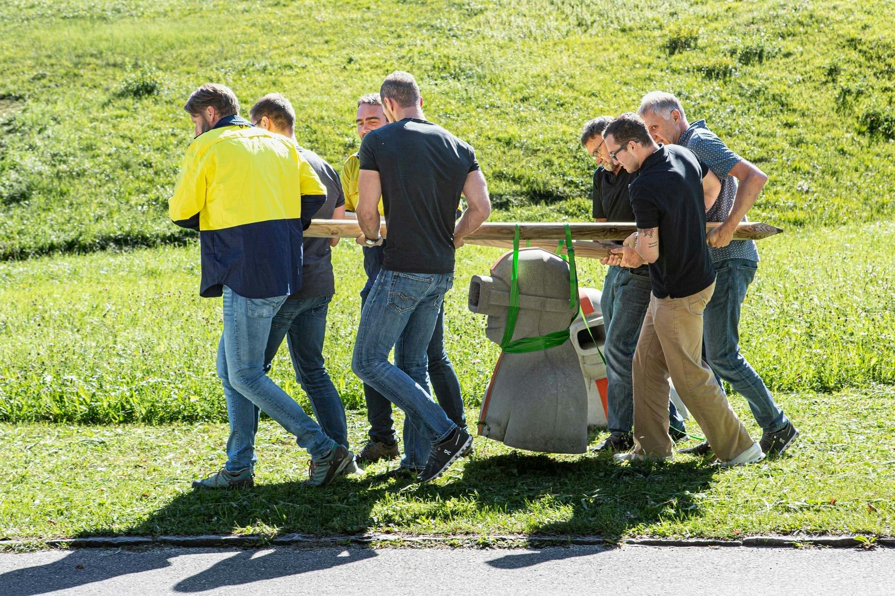 Mitarbeiter tragen eine Betonbüste.